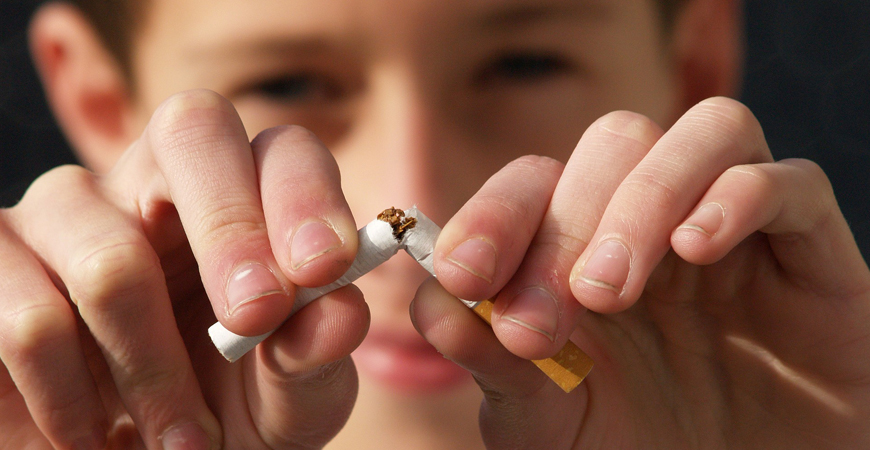 A person snaps a cigarette in half.